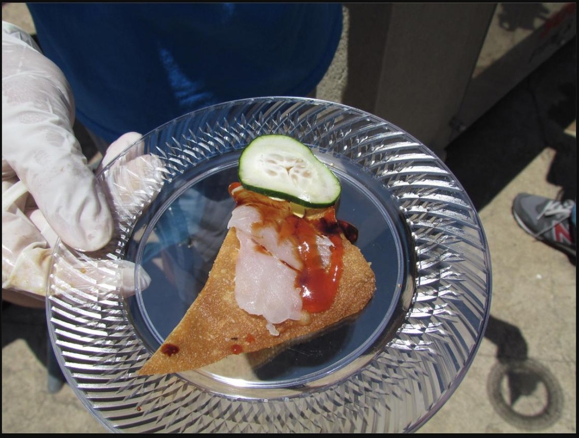 Citrus-cured lionfish ceviche served on a fried tostone, garnished with cucumber and hot sauce